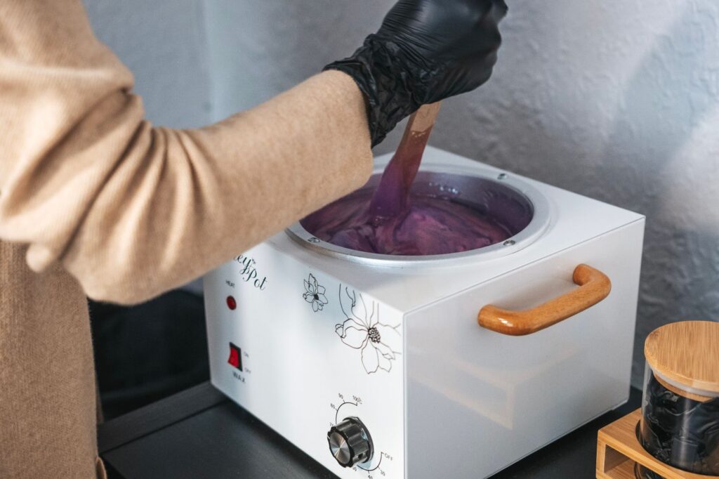 Therapist preparing warm wax in a private studio room